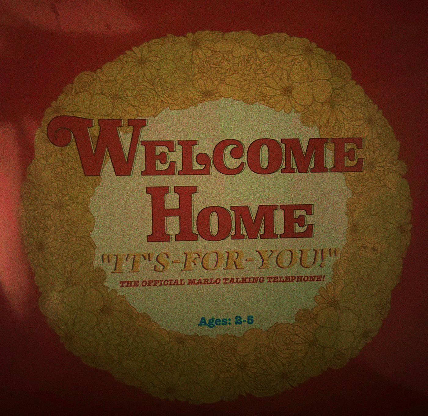 A photograph of the top of the box, it has the Welcome Home logo and says 'It's for you! The official Marlo Talking Telephone, Ages 2-5'